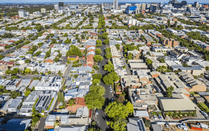 Overhead shot of a cityscape filled with trees, showcasing the balance between urban development and natural spaces.