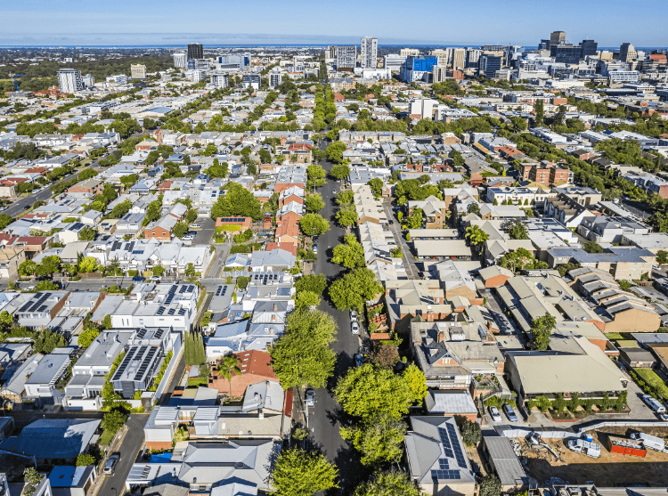 Overhead shot of a cityscape filled with trees, showcasing the balance between urban development and natural spaces.